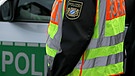 Symbolbild: Polizistin vor einem Polizeifahrzeug | Bild: picture-alliance/dpa