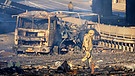 26.02.2022, Ukraine, Kiew: Ein ukrainischer Soldat geht an den Trümmern eines ausgebrannten Militärlastwagens vorbei. Russische Truppen haben den erwarteten Angriff auf die Ukraine gestartet und drangen in die Hauptstadt vor.  | Bild: dpa-Bildfunk/Efrem Lukatsky