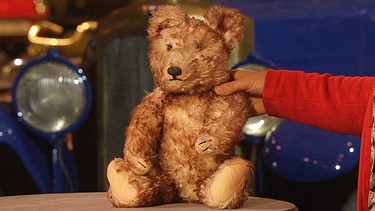 Nachweislich stammt dieser plüschige Teddybär mit zweifarbig angelegtem Mohairpelz von der ersten Nürnberger Spielwarenmesse im Jahre 1950. Nur wer ihn gefertigt hatte, blieb bisher ein Rätsel … Geschätzter Wert: 600 Euro | Bild: BR