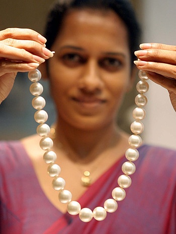 Frau hält Perlenkette vor sich | Bild: picture-alliance/dpa