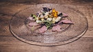 Die Vorspeise: Carpaccio vom Lammschinken, Spargel-Ingwer-Salat mit Wildkräutern. | Bild: BR/megaherz gmbh/Philipp Thurmaier