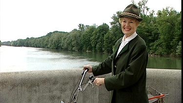 ältere Dame in Jägerstracht mit Fahrrad auf Brücke | Bild: BR