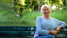 Rita Falk im Englischen Garten auf einer Bank. | Bild: BR/Tabea Hofmann