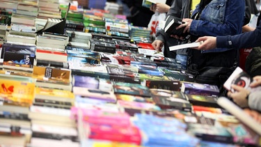 Archiv: Besucher der Leipziger Buchmesse 2012 stöbern an einem Büchertisch | Bild: picture-alliance/dpa