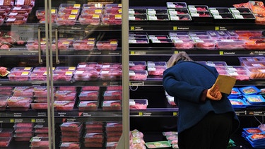 Eine Frau kauft abgepacktes Fleisch in einem Supermarkt. | Bild: picture alliance / dpa | Julian Stratenschulte