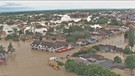 Häuser und Fahrzeuge stehen in einer Ortschaft unter Wasser. | Bild: BR