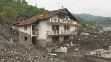 Ein Haus, an dem die Schlammspuren der Überschwemmung sichtbar sind. | Bild: BR