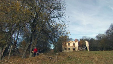 Ein verfallenes Haus in der Landschaft | Bild: BR