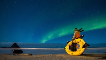 Kameramann Rick Rosenthal benutzt ein aufblasbares Kajak um sich leise den Walen nähern zu können. Für die Dreharbeiten war er auch in Bleik, Norwegen, wo das Nordlicht den Nachthimmel verzauberte. | Bild: NDR/doclights/TMFS/Wild Logic