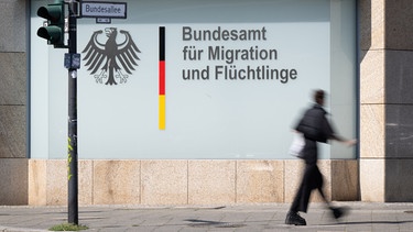 ARCHIV - 24.08.2023, Berlin: Ein Mann geht vor dem Bundesamt für Migration und Flüchtlinge vorbei. Foto: Sebastian Gollnow/dpa +++ dpa-Bildfunk +++ | Bild: dpa-Bildfunk/Sebastian Gollnow