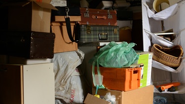 Viele aussortierte Gegenstände lagern aufeinander gestapelt in einem Raum. | Bild: stock.adobe.com/LitterART
