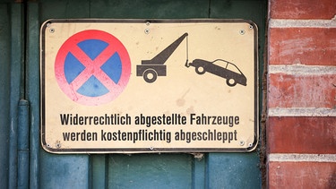 23.08.2023, Sachsen, Leipzig: Ein Schild an einem Garagentor weist darauf hin, das widerrechtlich abgestellte Fahrzeuge abgeschleppt werden. (zu dpa «BGH verhandelt über Ersatz der Kosten für die Verwahrung eines privat abgeschleppten Fahrzeugs») Foto: Jan Woitas/dpa +++ dpa-Bildfunk +++ | Bild: dpa-Bildfunk/Jan Woitas