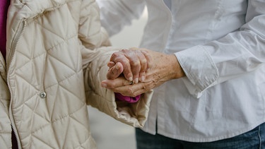 Eine Pflegerin stützt eine Seniorin. | Bild: BR/Johanna Schlüter
