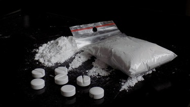 Beschlagnahmte Drogen: Lose, aufgehäuftes Kokain, Kokain in einem Plastikbeutel und synthetische Pillen. | Bild: stock.adobe.com/majo1122331