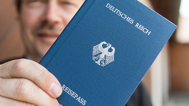Reichsbürger Joachim Widera posiert mit seinem "Deutsches Reich Reisepass" für den Fotografen (Archivbild). | Bild: picture-alliance/dpa/Patrick Seeger