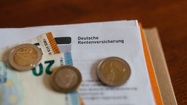 Ein Brief der Deutschen Rentenversicherung in einem Ordner mit Geld. | Bild: BR