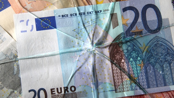 Eurogeldscheine unter einer zersplitterten Scheibe | Bild: picture-alliance/dpa