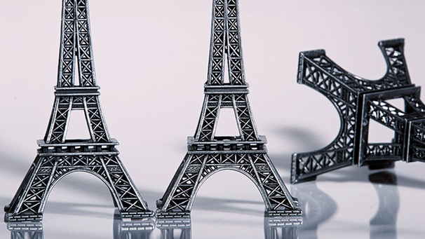 Zwei stehende Miniatureiffeltürme mit einem Umgeworfenen | Bild: picture-alliance/dpa