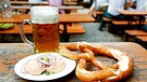 Eine Maß Bier, ein Teller Obazda und eine Riesenbrezel im Biergarten | Bild: picture alliance / Lajos-Eric Balogh | Lajos-Eric Balogh