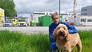 Grenztierarzt Dr. Henrik Tandler mit Flughund Freya auf dem Flughafengelände. | Bild: BR / Monika Sarre-Mock