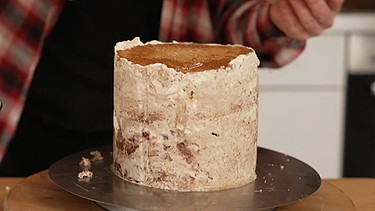 Eine erste dünne Schicht auf der Torte bindet die Krümel: die sogenannte Krümelschicht.  | Bild: BR