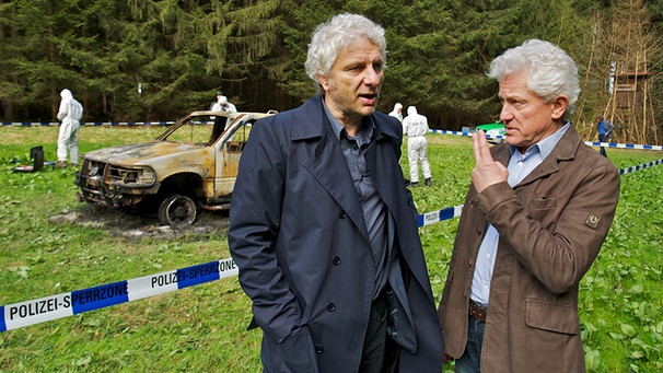 Franz Leitmayr (Udo Wachtveitl) und Ivo Batic (Miroslav Nemec) am ausgebrannten Autowrack, in dem eine verkohlte Leiche gefunden wurde. | Bild: BR/Bernd Schuller