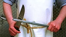 Ein Metzger beim Messerschärfen | Bild: picture alliance / photothek | Ute Grabowsky
