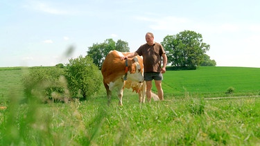 Markus Dillinger und eine seiner Kühe | Bild: BR