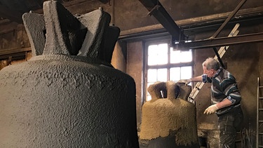 Für den Glockenmantel trägt Sepp Jungbauer eine weitere Lehmschicht auf. | Bild: BR/Matti Bauer/Sorin Dragoi