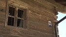 Unter unserem Himmel - Bauernhausgeschichten (Leben mit einem Denkmal): Neben einem eingeschlagenen Fenster eines Hauses in Datting hängt eine blau-weiße Plakate | Bild: BR