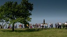 Unter unserem Himmel - Die Dörfer am Staffelberg: Eine Gruppe von Menschen läuft hintereinander über eine Wiese, im Vordergrund steht ein Baum. | Bild: BR