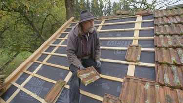 Häuserretter: Hermann Hauser deckt das Backhaus mit Schindeln, die bei Abbrucharbeiten andernorts auf der Bauschuttdeponie entsorgt wurden. | Bild: BR