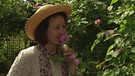 Unter unserem Himmel - Zeit für Rosen: Heilpraktikerin Maria Riedl riecht an einer Rose in ihrem Garten. | Bild: BR