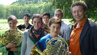 Wolfgang Diem (ganz rechts), Leiter der Musikschule Grassau, eine Gruppe junger Hornisten sowie unsere Moderatorin Annett Segerer. | Bild: BR