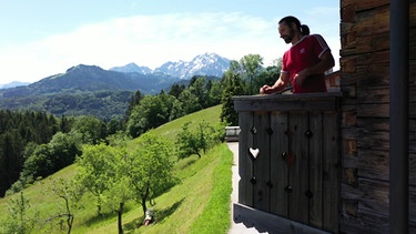 Kletterstar Alexander Huber auf dem Balkon seines Bauernhauses im Berchtesgadener Land | Bild: BR