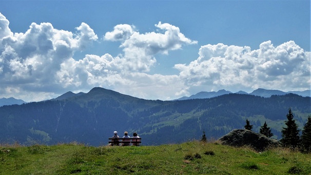 Wanderer sitzen auf einer Bank und genießen den Blick bis zum Großvenediger.  | Bild: BR/Annette Eckl