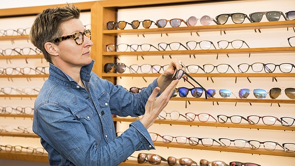 Frau sucht beim Optiker eine Brille aus | Bild: picture-alliance/dpa
