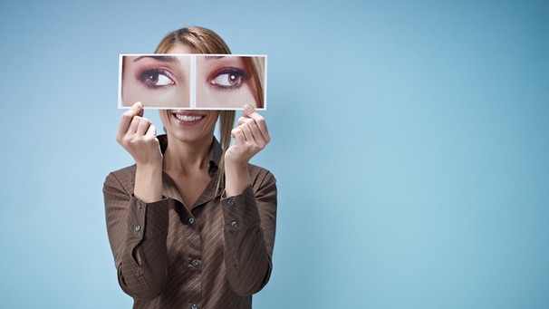 Eine Frau hält ein Bild mit schielenden Augen vors Gesicht | Bild: Colourbox
