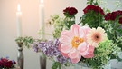 Blumen mit Kerzen im Hintergrund. | Bild: BR/Lisa Hinder