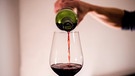 Rotwein wird in ein Glas eingeschenkt | Bild: BR / dpa-Bildfunk / Finn Winkler
