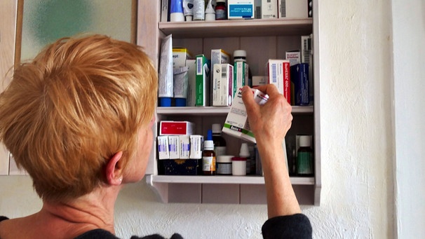 Eine Frau holt ein Medikament aus der Hausaoptheke | Bild: picture-alliance/dpa/ JOKER/Paul Eckenroth