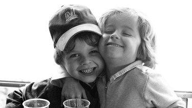 Zwei Jungs im Kindergartenalter, die sich am Tisch umarmen. | Bild: colourbox.com