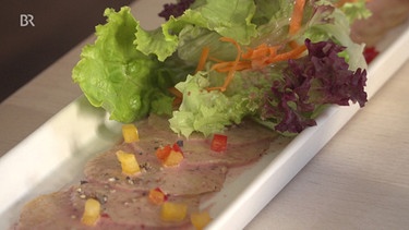 Semmelknödelcarpaccio in Sauerkirsch-Senf Dressing mit Blattsalaten und Weißbrot | Bild: Wir in Bayern