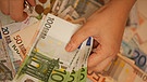 Eine Hand, die Hundert-Euro-Scheine hält. | Bild: colourbox.com