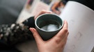 Hände umfassen eine dampfenden Teetasse | Bild: BR / Lisa Hinder