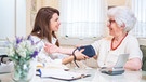Eine Pflegerin misst bei einer älteren Dame den Blutdruck. | Bild: stock.adobe.com/Bojan