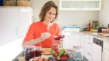 Frau macht Erdbeermarmelade in ihrer Küche.  | Bild: Picture Alliance 