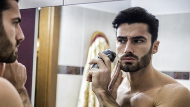 Mann rasiert sich vor dem Spiegel | Bild: BR / stock.adobe.com / starsstudio