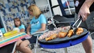Eine Person grillt Fleisch an einem Campingplatz | Bild: picture-alliance/dpa