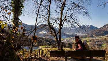 Nina Schlesener auf einer Bank mit Blick ins Tal | Bild: BR / Nina Schlesener